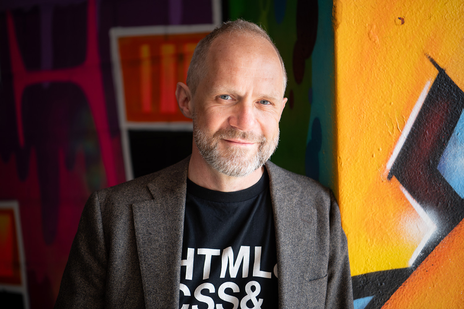 paul van buuren voor een muur met graffiti met een shirt waar HTML en CSS op staat